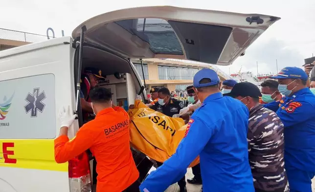 In this photo released by the Indonesian National Search and Rescue Agency (BASARNAS) on Monday, Dec. 29, 2025, rescuers put a body recovered from the water where tour boat sank near Padar Island into an ambulance in Labuan Bajo, Indonesia. (BASARNAS via AP)