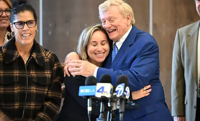 Attorney Russell Hardin Jr. hugs Tyler Skaggs' widow, Carli Skaggs, center, as Skaggs mother's Debbie smiles, at left, after a settlement was reached in the wrongful death lawsuit by the family of the Los Angeles Angels pitcher Friday, Dec. 19, 2025, in Orange County Superior Court, in Santa Ana, Calif. (AP Photo/William Liang)