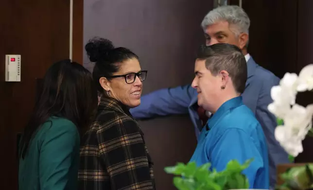 Tyler Skaggs mother, Debbie Skaggs, center, smiles in court after a settlement was reached in the wrongful death lawsuit by the family of pitcher Tyler Skaggs against the Los Angeles Angels in Orange County Superior Court in Santa Ana, Calif., Friday, Dec. 19, 2025. (Allen J. Schaben/Los Angeles Times via AP, Pool)