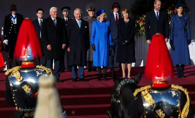 On the stage from left, German President Frank-Walter Steinmeier, Britain's King Charles III, Queen Camilla, wife of Steinmeier Elke Buedenbender, Prince William and Kate, Princess of Wales, attend a welcome ceremony on the Royal Dais at Datchet Road, in Windsor, England, Wednesday, Dec. 3, 2025. (Toby Melville/Pool Photo via AP)