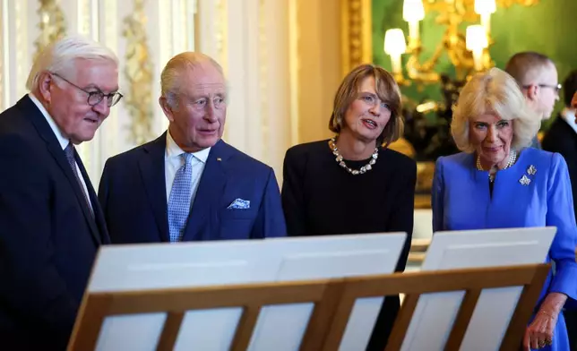 Britain's King Charles III, Queen Camilla, German President Frank-Walter Steinmeier and his wife Elke Buedenbender view items on display relating to Germany, during a visit to the Royal Collection exhibition in the Green Drawing Room at Windsor Castle, during Steinmeier's state visit to Britain, in Windsor, England, Wednesday, Dec. 3, 2025.(Hannah McKay/Pool Photo via AP)