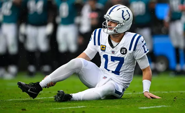 Indianapolis Colts quarterback Daniel Jones (17) grabs his leg after an injury during the first half of an NFL football game against the Jacksonville Jaguars, Sunday, Dec. 7, 2025, in Jacksonville, Fla. (AP Photo/Phelan M. Ebenhack)