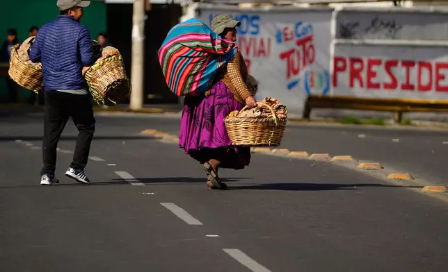 People walk during a strike by the public transportation sector in La Paz, Bolivia, Friday, Dec. 19, 2025, after President Rodrigo Paz announced the end of fuel subsidies. (AP Photo/Freddy Barragan)