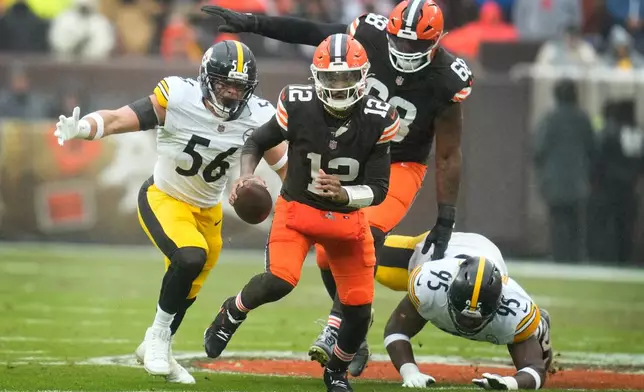 Cleveland Browns quarterback Shedeur Sanders (12) runs from Pittsburgh Steelers linebacker Alex Highsmith (56) and defensive tackle Keeanu Benton (95) during the first half of an NFL football game, Sunday, Dec. 28, 2025, in Cleveland. (AP Photo/Sue Ogrocki)