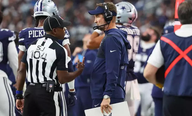 Dallas Cowboys head coach Brian Schottenheimer talks to a referee during the second half of an NFL football game against the Los Angeles Chargers, Sunday, Dec. 21, 2025, in Arlington, Texas. (AP Photo/Richard W. Rodriguez)