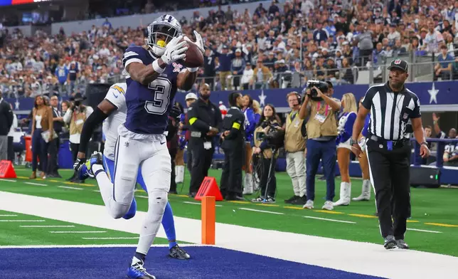 Dallas Cowboys wide receiver George Pickens (3) makes a touchdown catch past Los Angeles Chargers cornerback Cam Hart (20) during the first half of an NFL football game Sunday, Dec. 21, 2025, in Arlington, Texas (AP Photo/Richard W. Rodriguez)