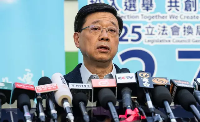 Hong Kong's Chief Executive John Lee speaks to the media at a polling station during the Legislative Council General Election in Hong Kong on Sunday, Dec. 7, 2025. (AP Photo/Chan Long Hei)