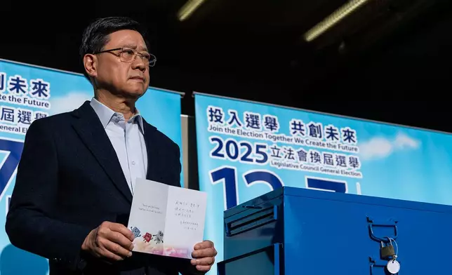 Hong Kong's Chief Executive John Lee, poses for photos at a polling station during the Legislative Council General Election in Hong Kong on Sunday, Dec. 7, 2025. (AP Photo/Chan Long Hei)