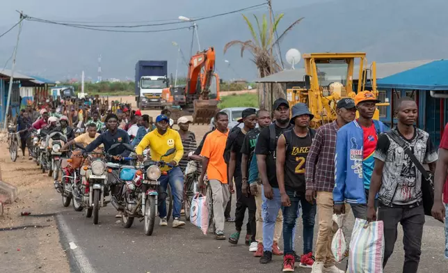 Burundian citizens who work in Uvira, Democratic Republic of the Congo, and could not cross back into their home country due to fighting, cross the border into Burundi, Sunday, Dec. 14, 2025. (AP Photo/Moses Sawasawa)