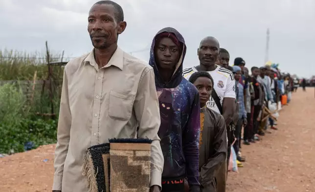 Burundian citizens who work in Uvira, Democratic Republic of the Congo, and could not cross back into their home country due to fighting, cross the border into Burundi, Sunday, Dec. 14, 2025. (AP Photo/Moses Sawasawa)