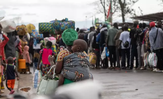 Burundian citizens who work in Uvira, Democratic Republic of the Congo, and could not cross back into their home country due to fighting, cross the border into Burundi, Sunday, Dec. 14, 2025. (AP Photo/Moses Sawasawa)