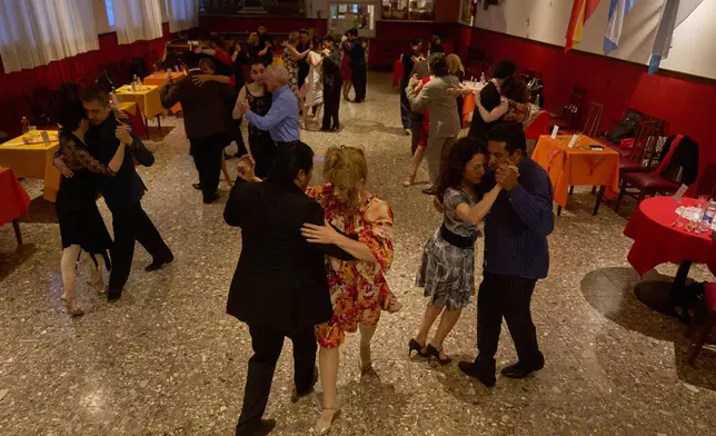 Beth Wolff, of German-Argentine, front right, dances with a professional tango dancer at the Che Che Tango Premium, where people can book guaranteed two‑hour dances with professional partners known as “Taxi Dancers," in Buenos Aires, Wednesday, Dec. 3, 2025. (AP Photo/Victor R. Caivano)