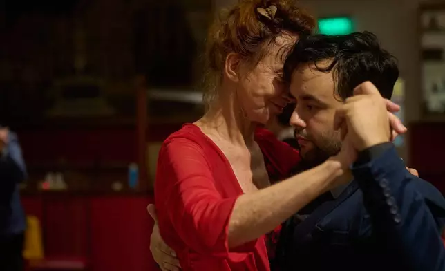 Antje Rickel, of France, left, dances with professional tango dancer Jared Ramos at the Che Che Tango Premium, where people can book guaranteed two‑hour dances with professional partners known as “Taxi Dancers," in Buenos Aires, Wednesday, Dec. 3, 2025. (AP Photo/Victor R. Caivano)