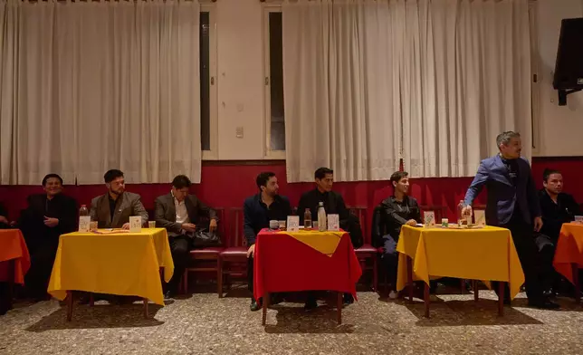 Professional tango dancers known as "Taxi Dancers" take a break at the Che Che Tango Premium, where people can book guaranteed two‑hour dances with professional partners in Buenos Aires, Wednesday, Dec. 3, 2025. (AP Photo/Victor R. Caivano)