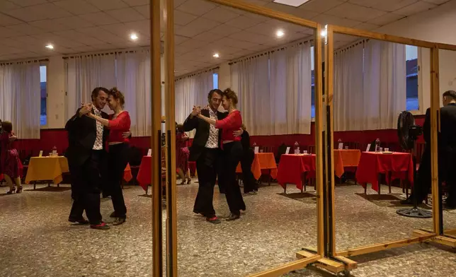 Antje Rickel, of France, right, dances with a professional tango dancer at the Che Che Tango Premium, where people can book guaranteed two‑hour dances with professional partners known as “Taxi Dancers," in Buenos Aires, Wednesday, Dec. 3, 2025. (AP Photo/Victor R. Caivano)