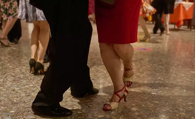 Women dance with professional tango dancers at the Che Che Tango Premium, where people can book guaranteed two‑hour dances with professional partners known as “Taxi Dancers," in Buenos Aires, Wednesday, Dec. 3, 2025. (AP Photo/Victor R. Caivano)