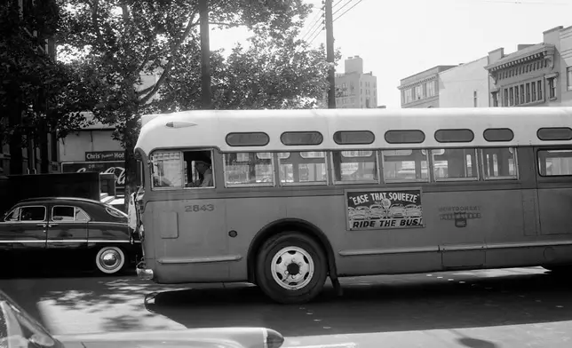 FILE - A man drives an empty bus through downtown Montgomery, Ala., April 26, 1956, during the Montgomery Bus Boycott. (AP Photo/Horace Cort, File)
