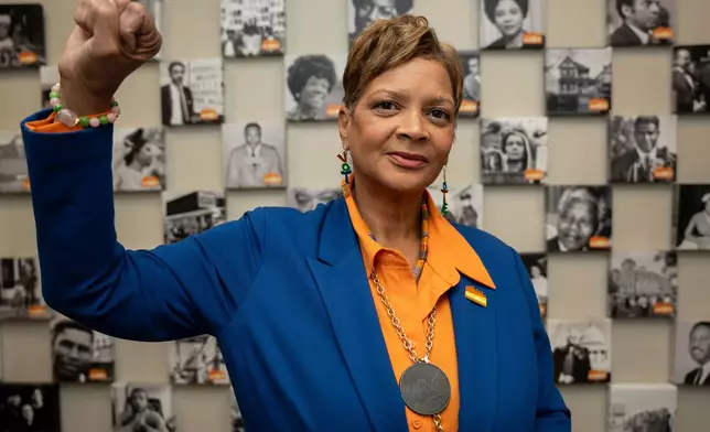 Deborah Scott, CEO of Georgia Stand-Up, raises her fist while standing in front of a wall honoring unsung heroes of the civil rights movement at The Movement Center, in Atlanta, Sunday, Nov. 30, 2025. (AP Photo/Olivia Bowdoin)