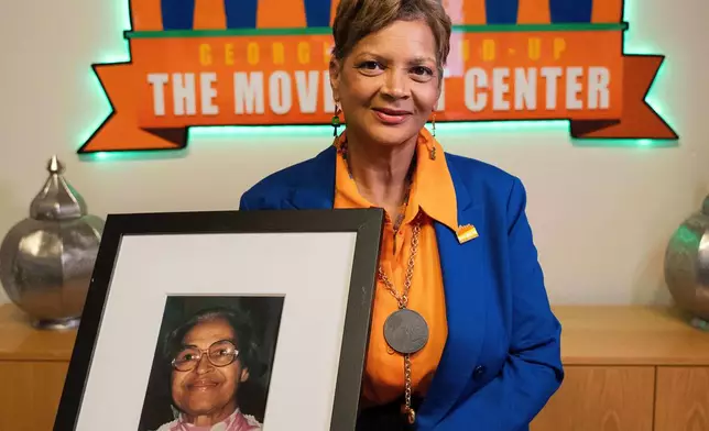 Deborah Scott, CEO of Georgia Stand-Up, holds a portrait of civil rights activist Rosa Parks, while marking the 70th anniversary of the Montgomery bus boycott at The Movement Center, in Atlanta, Sunday, Nov. 30, 2025. (AP Photo/Olivia Bowdoin)