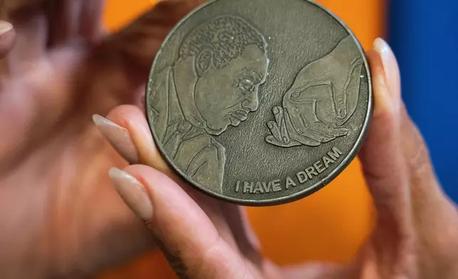 Deborah Scott holds a Martin Luther King Jr. commemorative medallion awarded to her as a symbolic passing of the baton to the next generation of civil rights leaders at The Movement Center, in Atlanta, Sunday, Nov. 30, 2025. (AP Photo/Olivia Bowdoin)