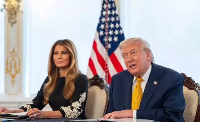 President Donald Trump, accompanied by first lady Melania Trump, speaks during a call with service members at his Mar-a-Lago club, Wednesday, Dec. 24, 2025, in Palm Beach, Fla. (AP Photo/Alex Brandon)