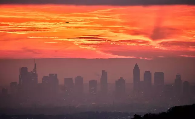 The sky is coloured red before sunrise in Frankfurt, Germany, Friday, Dec. 12, 2025. (AP Photo/Michael Probst)