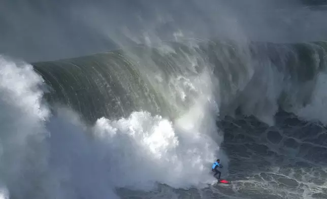 Surfer Rafael Tapia, from Chile, rides a wave during the Nazare Big Wave Challenge surfing tournament at Praia do Norte, or North Beach, in Nazare, Portugal, Saturday, Dec. 13, 2025. (AP Photo/Ana Brigida)