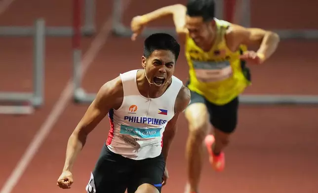 Philippines John Christopher Tolentino celebrates after winning in the men's 110m hurdles final race at the 33rd Southeast Asian Games in Bangkok, Thailand, Friday, Dec 12, 2025. (AP Photo/Achmad Ibrahim)