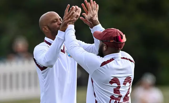 West Indies' Roston Chase, left, and teammate John Campbell celebrate after taking the wicket of New Zealand's Nathan Smith during their cricket test match in Christchurch, New Zealand, Tuesday, Dec. 2, 2025. (John Davidson/Photosport via AP)