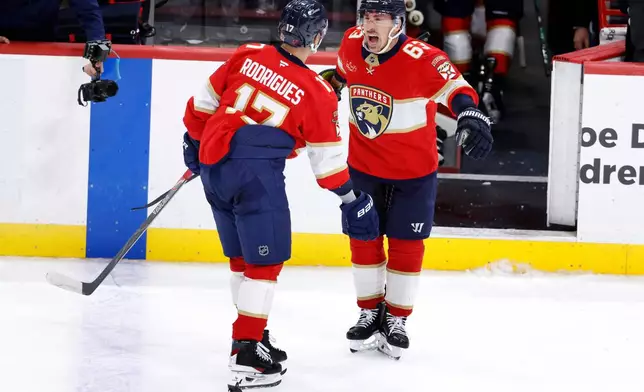 Florida Panthers center Evan Rodrigues (17) and left wing Brad Marchand (63) celebrate their win against the Washington Capitals following an NHL hockey game, Monday, Dec. 29, 2025, in Sunrise, Fla. (AP Photo/Rhona Wise)