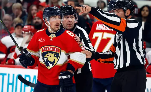 Florida Panthers' Brad Marchand (63) looks at referee Francois St Laurent (8) as he heads to the penalty box during the second period of an NHL hockey game against the Florida Panthers in Raleigh, N.C., Tuesday, Dec. 23, 2025. (AP Photo/Karl DeBlaker)