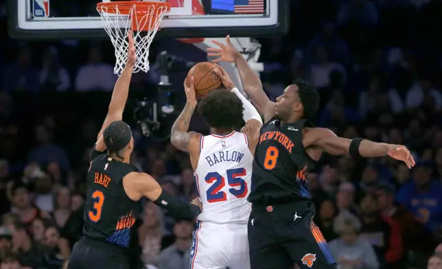 New York Knicks guard Josh Hart, left, and forward OG Anunoby, right, defend against Philadelphia 76ers forward Dominick Barlow, middle, during the first half of an NBA basketball game, Friday, Dec. 19, 2025, in New York. (AP Photo/John Munson)