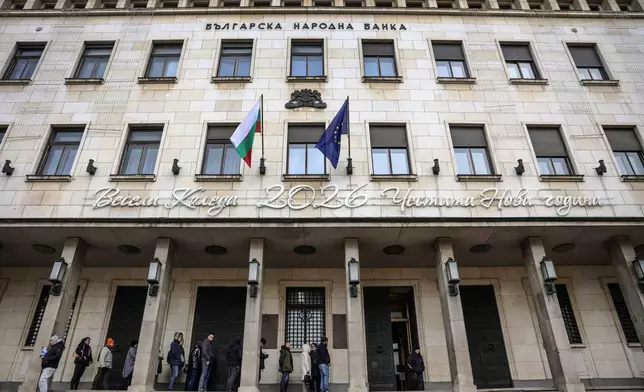 People wait in line to buy packages of new Euro coins with Bulgarian symbols at the doorstep of Bulgarian National Bank, in Sofia, Saturday Dec. 27, 2025. (AP Photo/Valentina Petrova)
