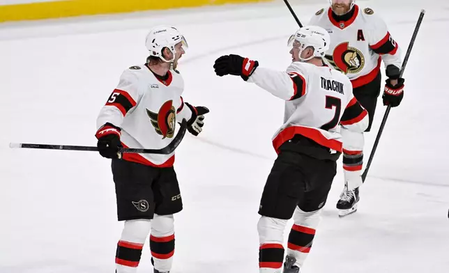 Ottawa Senators' Jake Sanderson, left, celebrates after his tying goal against the Winnipeg Jets with Brady Tkachuk (7) and Claude Giroux (28) during the third period of an NHL hockey game in Winnipeg, Manitoba, Monday, Dec. 15, 2025. (Fred Greenslade/The Canadian Press via AP)
