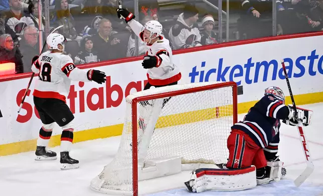 Ottawa Senators' Brady Tkachuk (7) celebrates after his winning goal in overtime against Winnipeg Jets' goaltender Connor Hellebuyck, right, with Tim Stulzle (18) during an NHL hockey game in Winnipeg, Manitoba, Monday, Dec. 15, 2025. (Fred Greenslade/The Canadian Press via AP)
