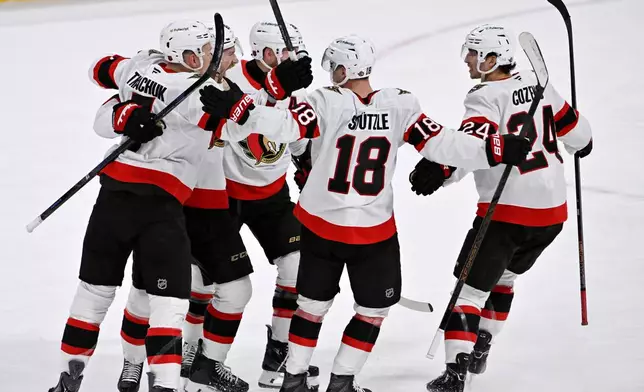 Ottawa Senators Jake Sanderson, second from left, celebrates after his tying goal against the Winnipeg Jets with teammates during the third period of an NHL hockey game in Winnipeg, Manitoba, Monday, Dec. 15, 2025. (Fred Greenslade/The Canadian Press via AP)