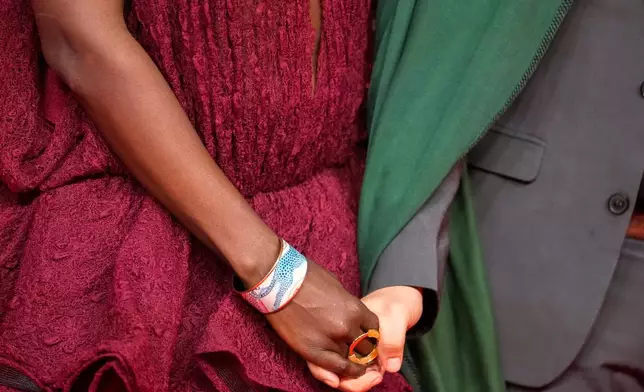A couple poses for a photo on the red carpet during the 22nd Marrakech Film Festival, in Morocco, Tuesday, Dec. 2, 2025. (AP Photo/Mosa'ab Elshamy)