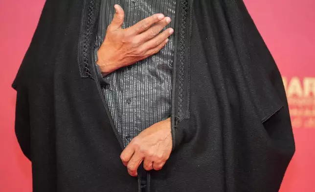 A moroccan actor poses for a photo wearing a traditional outfit on the red carpet during the opening ceremony of the 22nd Marrakech Film Festival, in Morocco, Friday, Nov. 28, 2025. (AP Photo/Mosa'ab Elshamy)