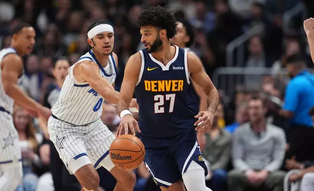 Denver Nuggets guard Jamal Murray, front, drives to the basket as Orlando Magic guard Anthony Black defends in the first half of an NBA basketball game, Thursday, Dec. 18, 2025, in Denver. (AP Photo/David Zalubowski)