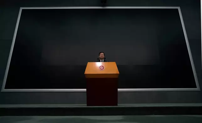 Hong Kong Chief Executive John Lee speaks during a press conference with a darken screen in the aftermath of a deadly fire in Hong Kong on Tuesday, Dec. 2, 2025. (AP Photo/Ng Han Guan)