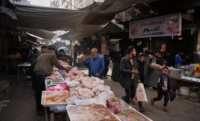 A Palestinian looks at chicken cuts displayed for sale at a local street market in Gaza City, Friday, Dec. 19, 2025. (AP Photo/Abdel Kareem Hana)