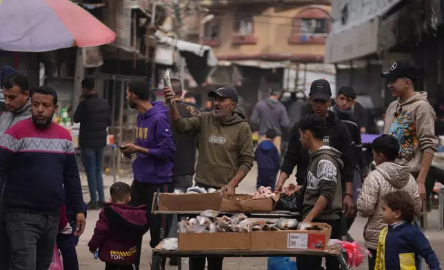 A Palestinian vendor displays sardines for sale on a street of a local market in Gaza City, Friday, Dec. 19, 2025. (AP Photo/Abdel Kareem Hana)