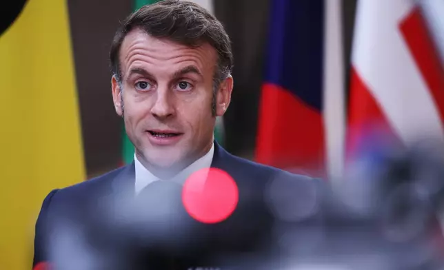 French President Emmanuel Macron speaks with the media as he arrives for the EU Summit in Brussels, Thursday, Dec. 18, 2025. (AP Photo/Omar Havana)