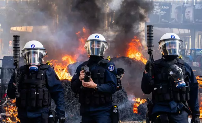 Police try to disperse protestors during a demonstration of European farmers near the European Parliament in Brussels, Thursday, Dec. 18, 2025. (AP Photo/Marius Burgelman)