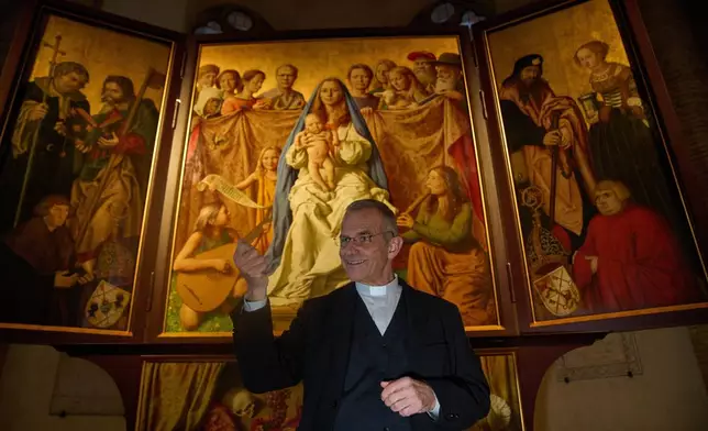 Mons. Peter Klasvogt, the rector of the Teutonic College talks during an interview with the Associated Press next to a painting exposed in the chapel of the Teutonic College by German artist Michael Triegel, who portrayed as St. Peter Burkhard Scheffler, a homeless man who died from the cold in 2022 on the edge of St. Peter's Square, at the Vatican, Wednesday, Dec. 10, 2025. (AP Photo/Alessandra Tarantino)