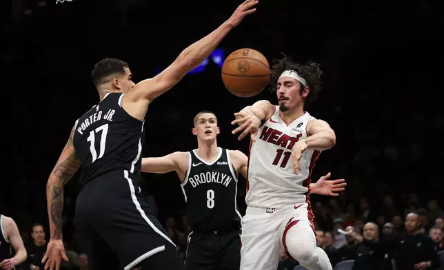 Miami Heat forward Jaime Jaquez Jr. (11) passes the ball around Brooklyn Nets forward Michael Porter Jr. (17) during the first half of an NBA basketball game, Thursday, Dec. 18, 2025, in New York. (AP Photo/Heather Khalifa)