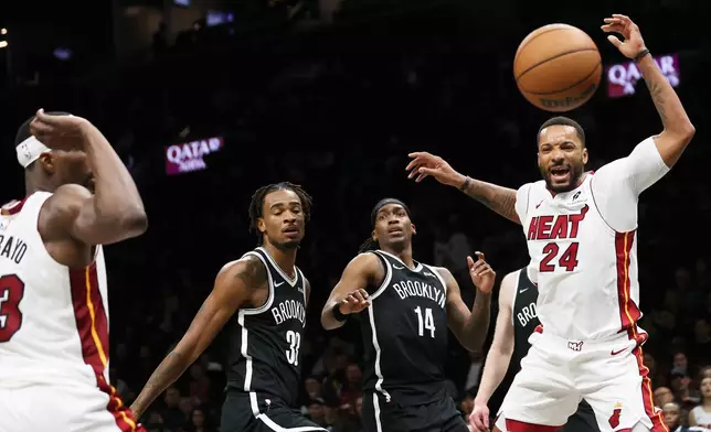 Miami Heat guard Norman Powell (24) loses the ball against Brooklyn Nets defenders during the first half of an NBA basketball game, Thursday, Dec. 18, 2025, in New York. (AP Photo/Heather Khalifa)