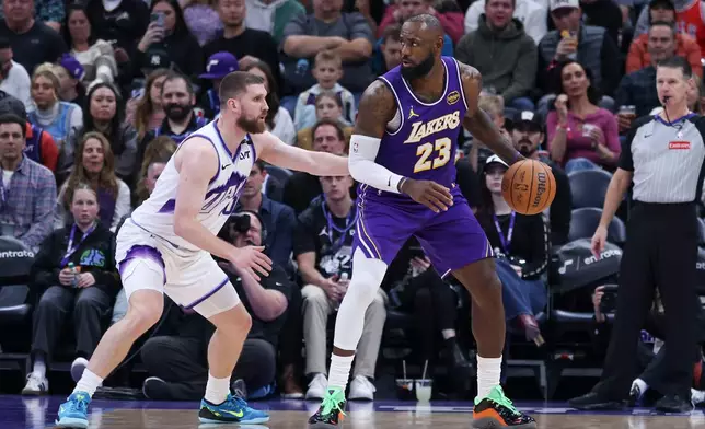 Los Angeles Lakers forward Lebron James (23) posts up against Utah Jazz guard Svi Mykhailiuk, left, during the second half of an NBA basketball game, Thursday, Dec. 18, 2025, in Salt Lake City. (AP Photo/Rob Gray)