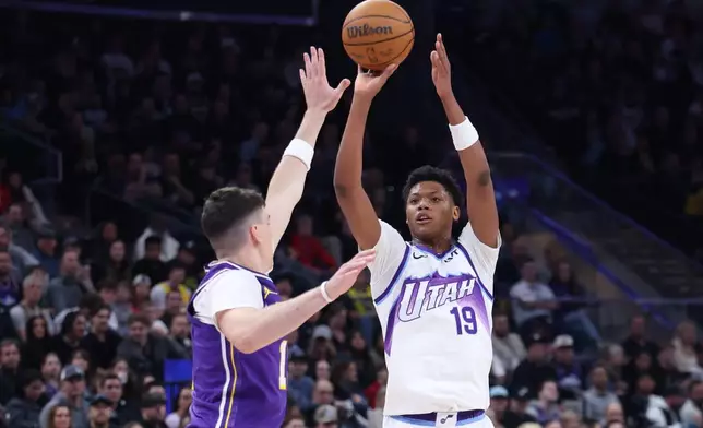 Utah Jazz guard Ace Bailey (19) looks. to shoot a 3-point basket over Los Angeles Lakers forward Jake Laravia, left, during the second half of an NBA basketball game, Thursday, Dec. 18, 2025, in Salt Lake City. (AP Photo/Rob Gray)