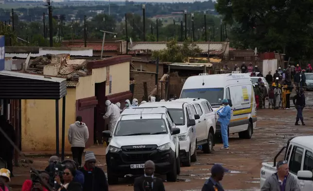 South African police gather at the scene of a mass shooting where gunmen killed nine and injured at least 10 in a pub in Bekkersdal, South Africa, Sunday, Dec. 21, 2025. (AP Photo/ Alfonso Nqunjana)